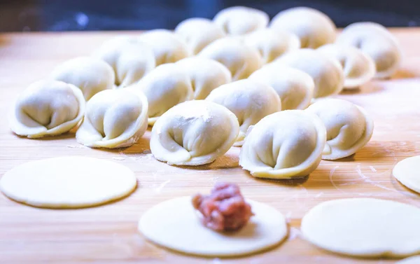 The process of making dumplings. Dumplings - Russian on a wooden background. — Stock Photo, Image