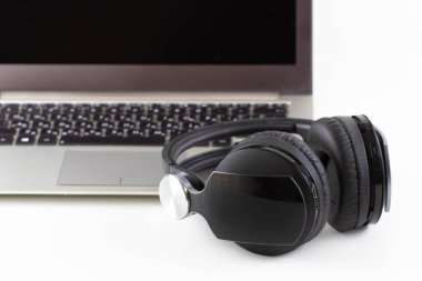 Beyaz arka planda kulaklık ve bilgisayar.