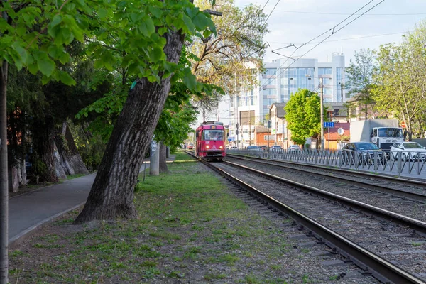 A red tram rides on rails in the city. — Stock Photo, Image