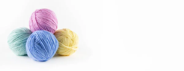 Beyaz arkaplanda renkli iplik topları.