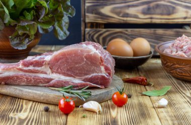 Kesme tahtasında çiğ domuz eti ve sebze..