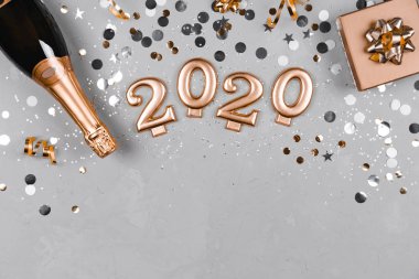 Şampanya, hediye kutusu ve konfetiden oluşan düz bir kompozisyon..