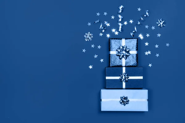 Merry Christmas gift box with ribbon bow on blue festive background. — Stock Photo, Image