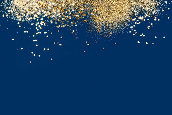 Festive gold confetti on classic blue background. — Stock Photo, Image