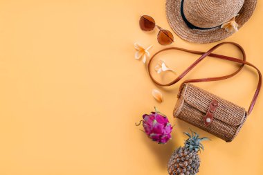 Sarı arka planda, meyve, çanta, şapka ve güneş gözlüklü düz gezgin aksesuarları vardı..