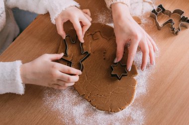 Genç anne ve küçük kızı ev mutfağında birlikte kurabiye pişiriyorlar..