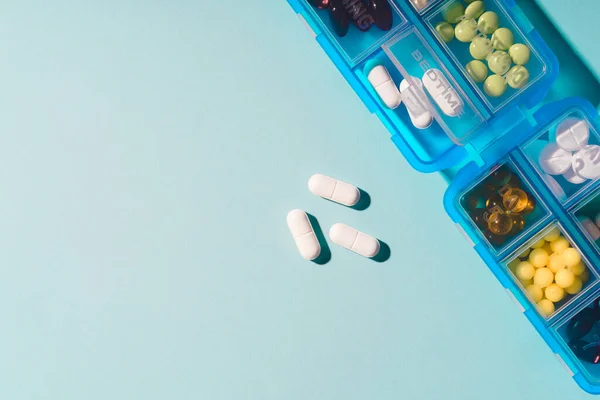 Pudełko z lekami. Tabletki na receptę i witaminy w niebieskim pudełku. — Zdjęcie stockowe