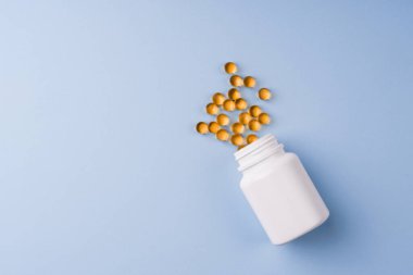 Mavi arka planda Omega 3 balık yağı kapsülleri.