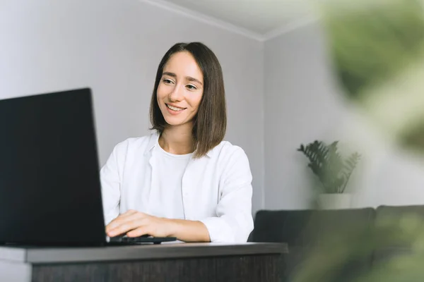 Πορτραίτο νεαρής γυναίκας με φορητό υπολογιστή στο γραφείο του σπιτιού. — Φωτογραφία Αρχείου