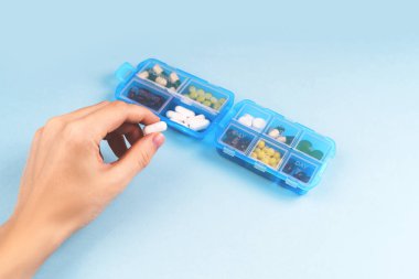 İlaç dozu kutusu. Mavi ilaç kutusunda reçeteli ilaç ve vitaminler..