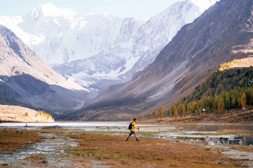 Man Traveler with backpack mountaineering in Altai mountain near Ak-Kem lake, Siberia, Russia. Travel Lifestyle concept.