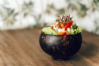 Arka planda ton balığı, avokado, sebze ve susamlı poke kasesi..