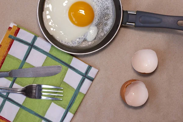 Jajko smażone na patelni, skorupki jaj, ręcznik, nóż i widelec, awokado — Zdjęcie stockowe