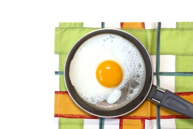 Tavada yumurta ve beyaz arka planda bulaşık havlusu..