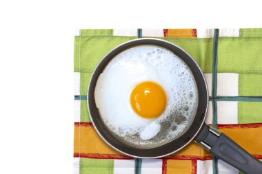 Tavada yumurta ve beyaz arka planda bulaşık havlusu..