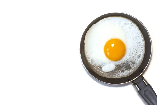 Białe tło ze smażonym jajkiem na patelni — Zdjęcie stockowe