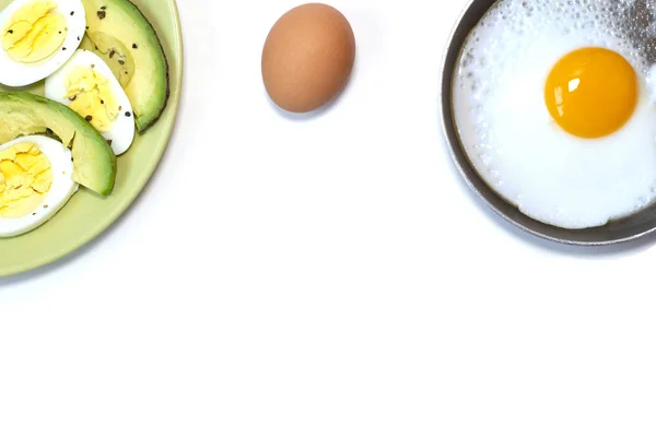 Jajko smażone na patelni, zielony talerz z jajkiem gotowanym i awokado na białym stole — Zdjęcie stockowe