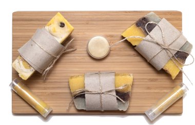 Tahtada el yapımı sabun ve dudak kremi var.