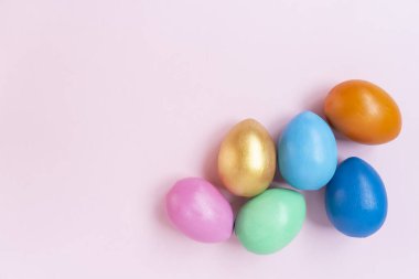 Pembe arka planda renkli yumurtalar. Boşluğu kopyala.