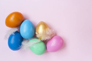 Pembe arka planda renkli yumurtalar. Boşluğu kopyala.