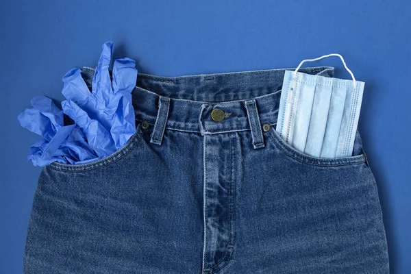 Niebieskie dżinsy z maską medyczną i rękawiczkami — Zdjęcie stockowe