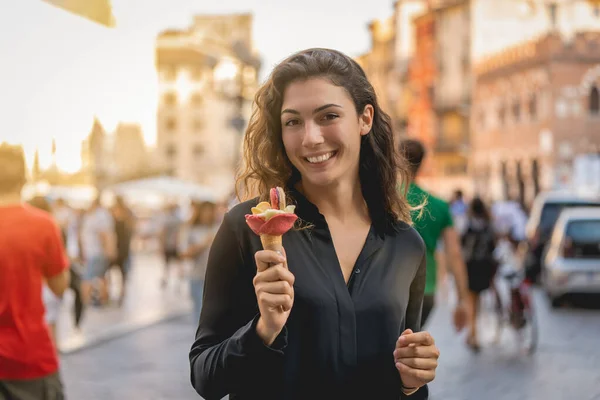Lachend toeristisch meisje wandelen met ijs voor een stad, vakantie — Stockfoto