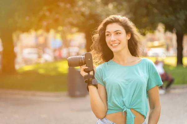 Glimlachende jonge vrouw maakt foto 's in de stad — Stockfoto