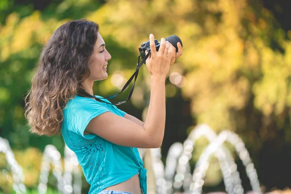 Glimlachend meisje in een Italiaanse stad met een camera in haar hand. — Stockfoto