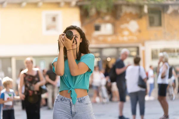 Chica fotógrafa turística o profesional que dispara en una ciudad típica italiana . —  Fotos de Stock