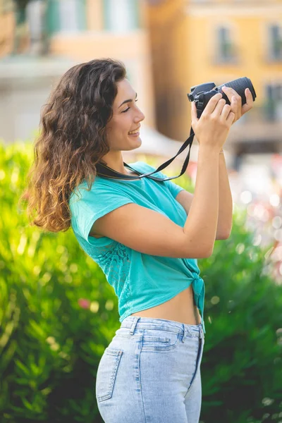 Glimlachend meisje in een Italiaanse stad met een camera in haar hand. — Stockfoto