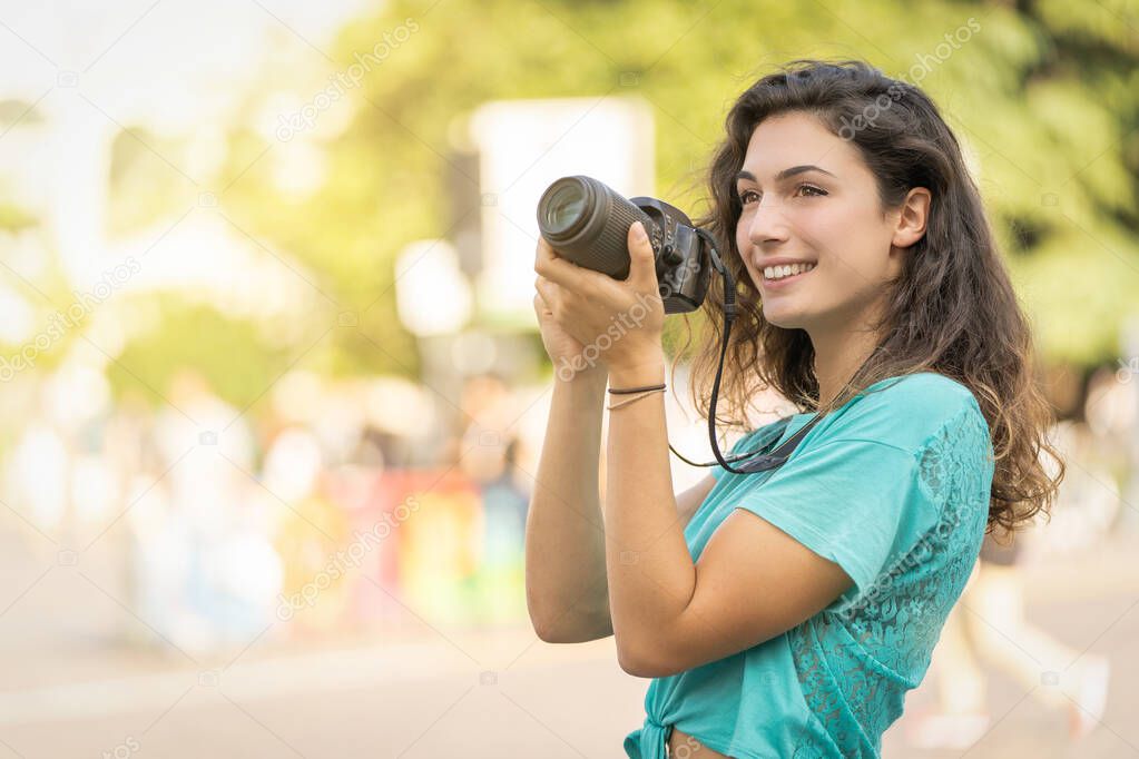 Smiling girl in an Italian city with a camera in her hand. 
