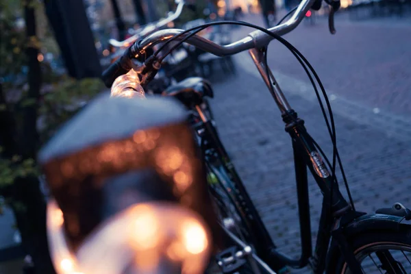 Manillar de una bicicleta apoyado contra la barandilla por la noche — Foto de Stock