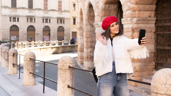 Elegancka kobieta turystka robi zdjęcie przed amfiteatrem, starożytność, Europa — Zdjęcie stockowe