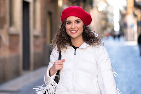 Mulher feliz andando na rua com chapéu vermelho e feliz Imagem De Stock