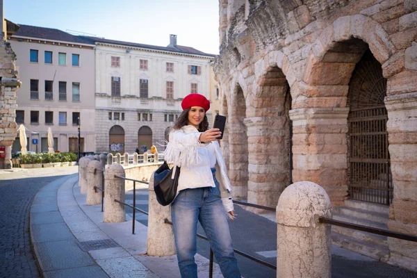 Elegáns turista nő fényképez az amfiteátrum előtt, ókor, Európa — Stock Fotó