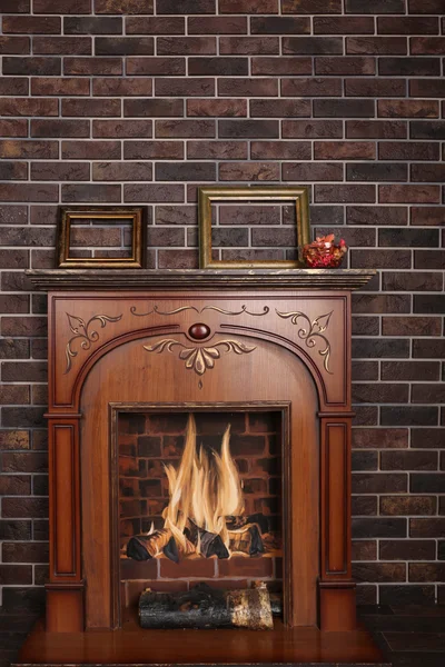 Decorative fireplace in the room on a dark brick background