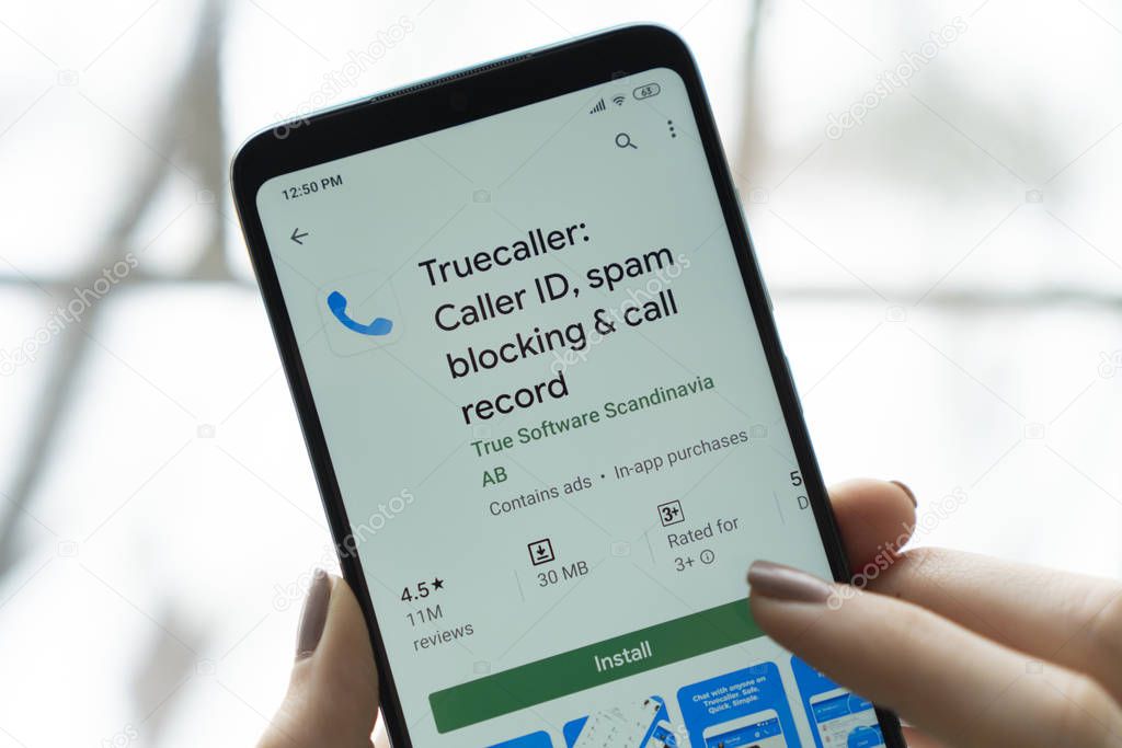 New York - January 9, 2020: Truecaller app on a smartphone with a finger above the screen.  Truecaller is a application for blocking spam calls and SMS.