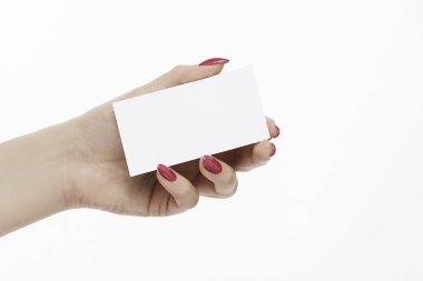 Kırmızı tırnakları ve kartviziti olan zarif bir kadın eli.