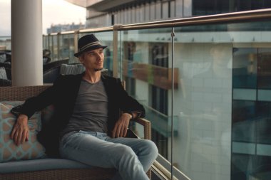 Balkonda şapkalı bir adam.