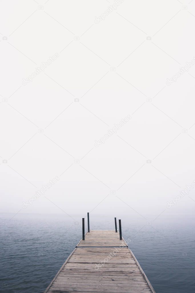 Dock on the lake in the fog during summer