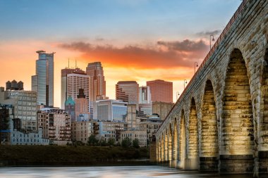 Gün batımında Minneapolis 'te Stone Arch Köprüsü ışıkları