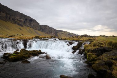 Bjodvegur yolu yakınlarındaki küçük şelalenin panoramik yaz manzarası. Vay canına.
