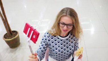 Genç bir kadın bir kafe, yaşam tarzı ve teknoloji konseptinde canlı yayın yönetiyor.