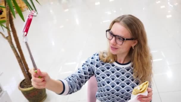 En ung kvinna leder en direktsändning i ett kafé, livsstil och teknik koncept — Stockvideo