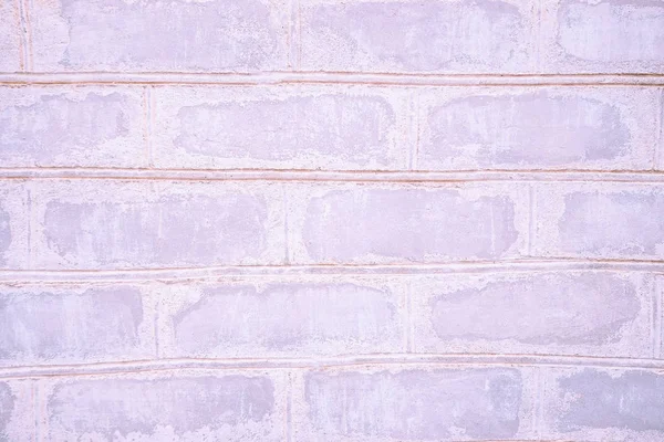Pink old neon brick wall close-up with stitching. The texture of the stone masonry. Stone background for a subject shooting a flat lay. Concept of construction and interior design. Copy space