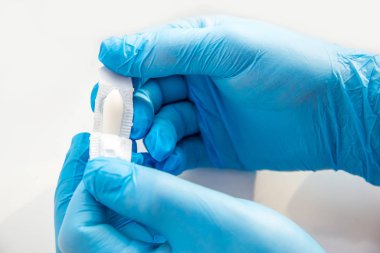 Eldivenli bir doktor anal ya da vajinal kullanım için fitil açar. Candida tedavisi için tıbbi mumlar, ardıç kuşu, hemoroit, iltihap ve ateş. Beyaz arka planda etkili uyuşturucu