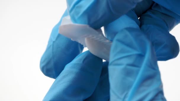 A gloved doctor opens suppositories for anal or vaginal use. Medical candles for the treatment of Candida, thrush, hemorrhoids, inflammation and fever. Effective drug on a white background — Stock Video © blinova.tl #325914530