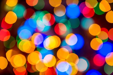 Noel 'in renkli parlak arkaplanı. Şenlikli soyut Bokeh siyah arkaplandaki büyük renkli ışıkların dikkatini dağıttı. Boşluğu kopyala