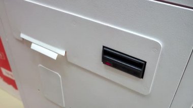 ATM 'den çek alan bir adamın yakın çekimi. Kredi geri ödeme kavramı, elektrik faturaları ve internet alımları. Ödeme hizmetleri için Rusça terminal.