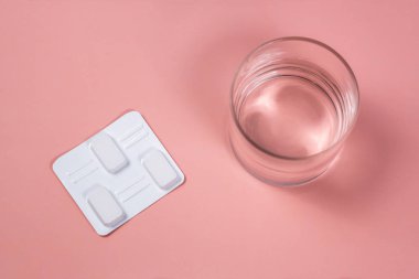 Pembe arka planda beyaz vajinal antibakteriyel haplar. Mumlar suya batırılıp vajinaya enjekte edilerek kandiyaz, ardıç, iltihap tedavisi görülür. Hastalıkların tedavisi için etkili modern ilaç